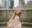 woman in pink long sleeve dress sitting on concrete bench during daytime