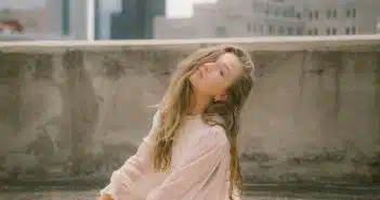 woman in pink long sleeve dress sitting on concrete bench during daytime