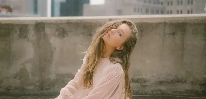 woman in pink long sleeve dress sitting on concrete bench during daytime
