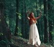 woman wearing white high-low dress in middle of woods during daytime