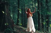 woman wearing white high-low dress in middle of woods during daytime