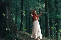 woman wearing white high-low dress in middle of woods during daytime