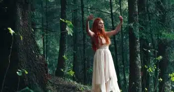 woman wearing white high-low dress in middle of woods during daytime