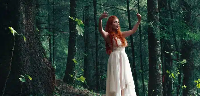 woman wearing white high-low dress in middle of woods during daytime