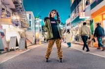 woman in green jacket stands and pose on street