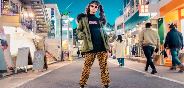 woman in green jacket stands and pose on street