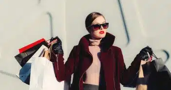 photo of woman holding white and black paper bags