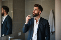 Homme barbu en train de tailler sa barbe dans une salle de bain moderne